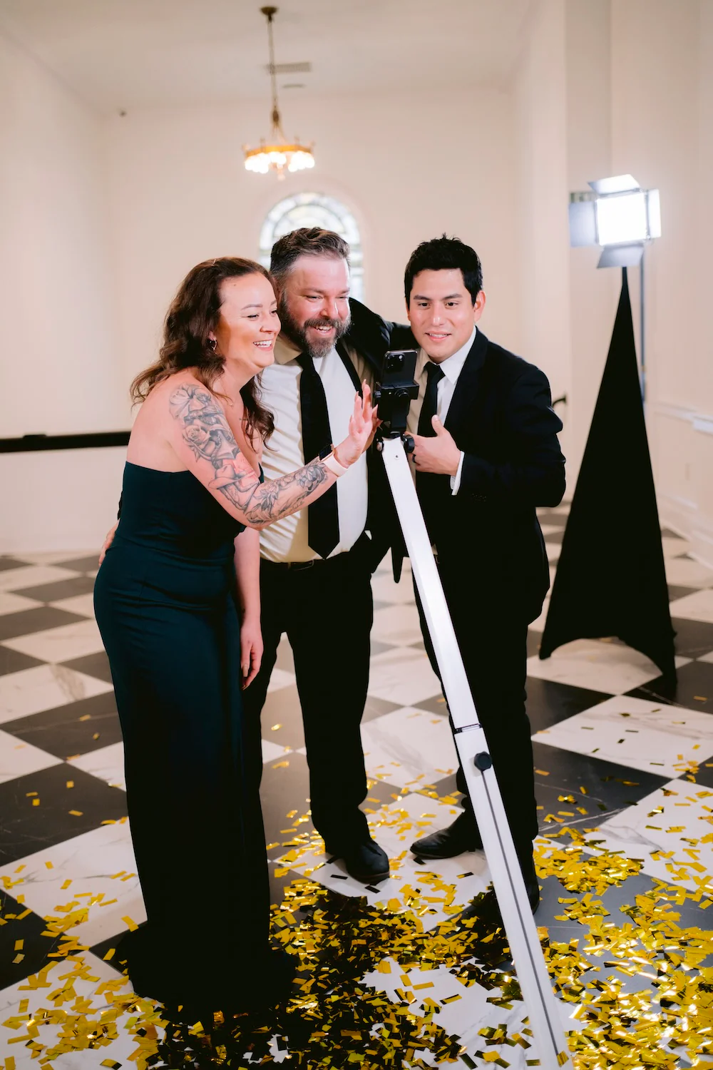 Three guests using a 360 photo booth rental at a Bend, Oregon black-tie event