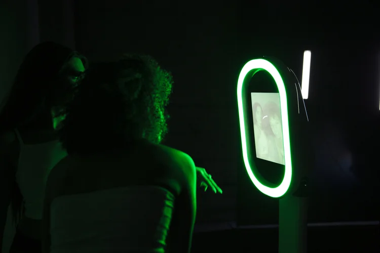 Guests using the Bend Booth mirror photo booth lit in green at a Central Oregon event