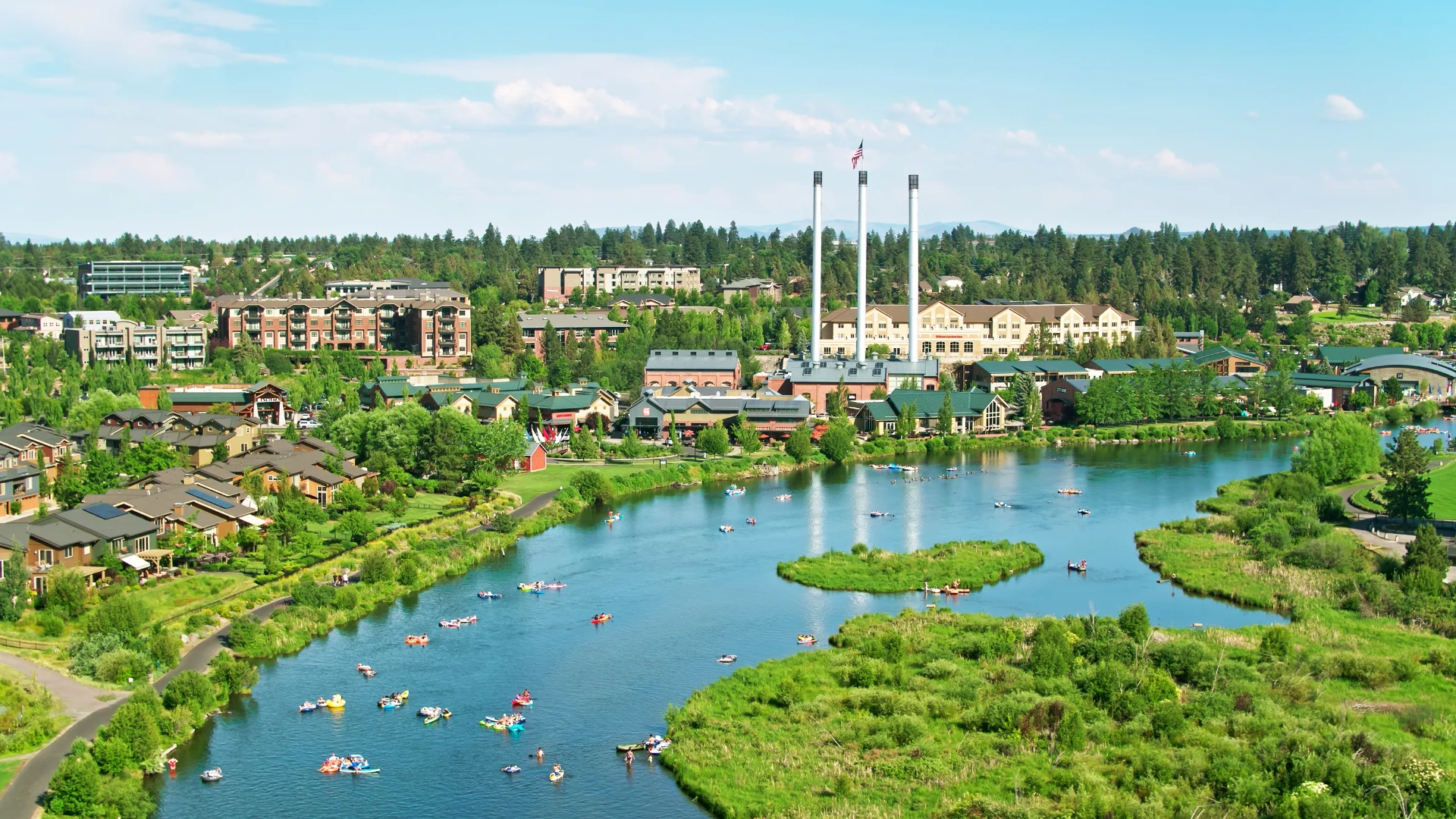 Aerial view of the Old Mill District and Deschutes River in Bend, Oregon with floaters on the water